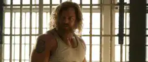 Dramatic scene from Bottled Tastes with a rugged man in prison setting.