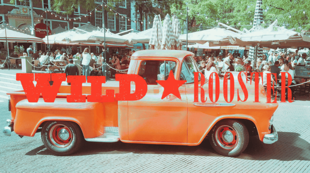 Vintage orange truck with Wild Rooster logo at The Hague festival.