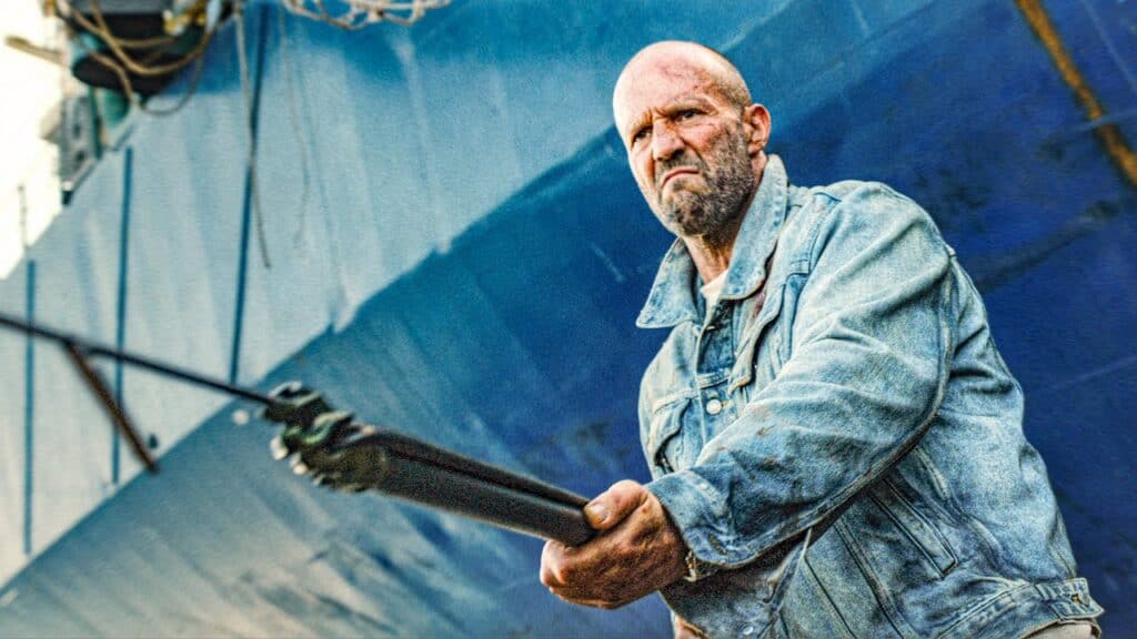 Serious man holding a weapon at a festival or event.