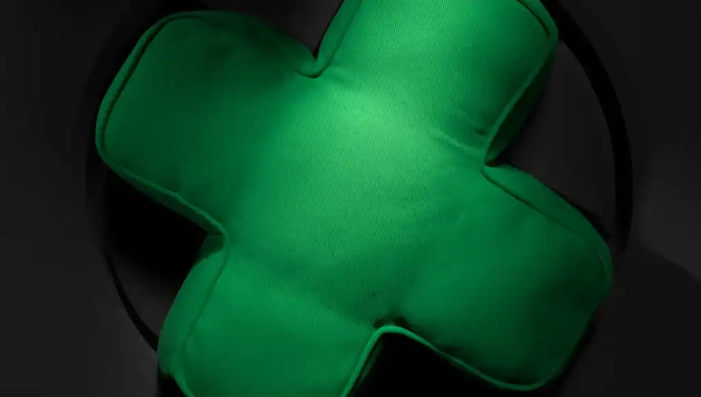 Green plush cross symbol representing health and wellness.
